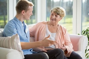 Male nurse and senior woman sitting on the couch